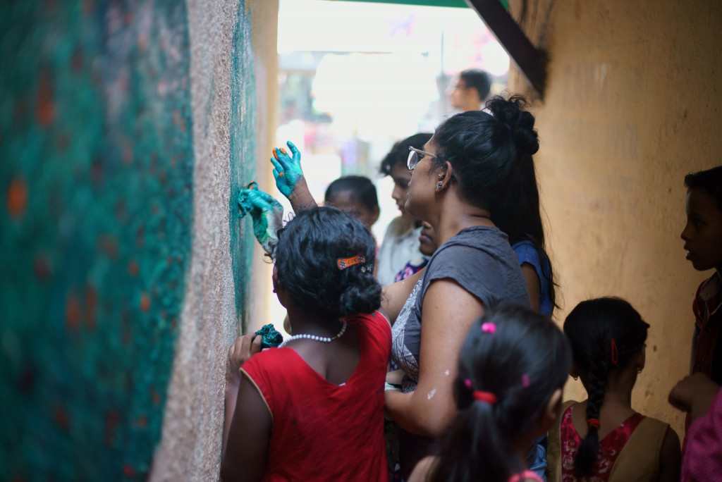 woman painting the wall with the children
