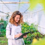 woman checking her list while inside her greenhouse farm