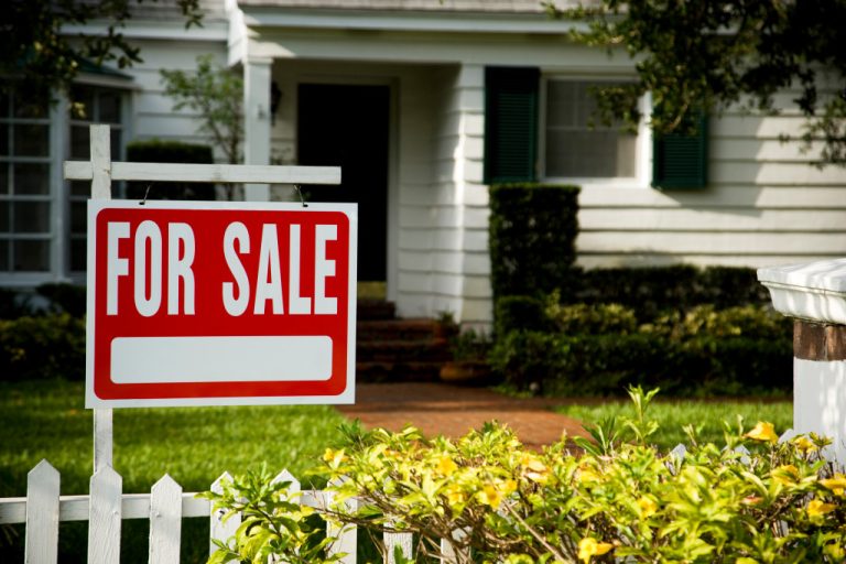 for sale sign in front of a house
