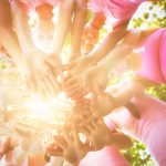 group of people dressed in pink lined up in a circle with sunlight in the middle