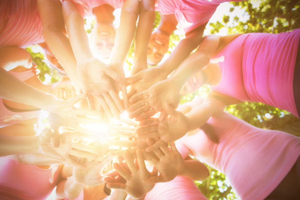 group of people dressed in pink lined up in a circle with sunlight in the middle