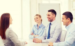 A confident woman in front of professionals during a job interview feeling confident