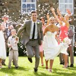 Wedding guests throwing confetti over newlyweds