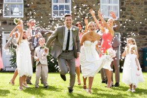 Wedding guests throwing confetti over newlyweds