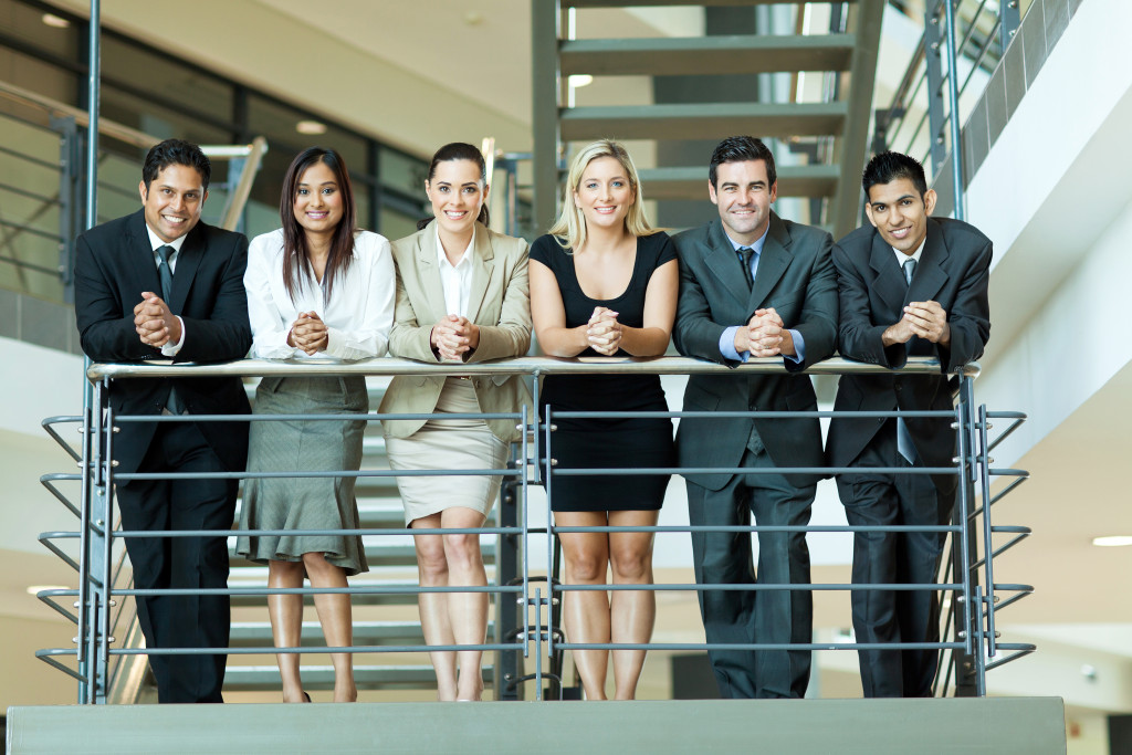 smiling employees standing in staircase