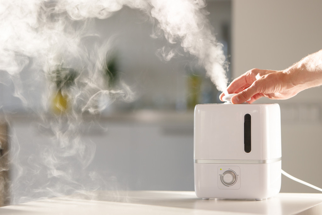 person turning on an air humidifier device at home
