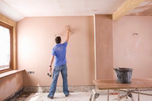 a man using a plaster on the wall