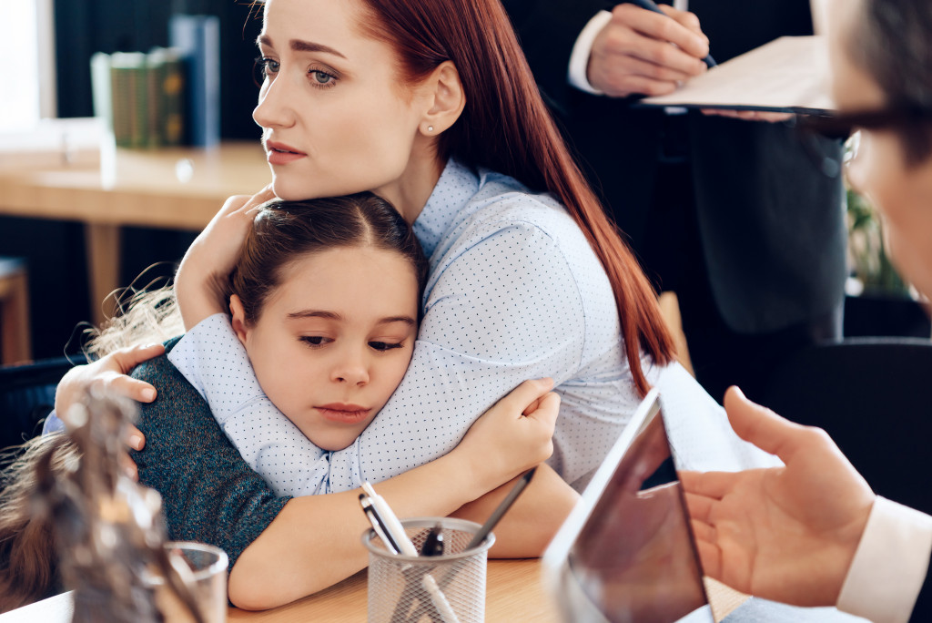 mother hugging daughter in lawyer's office